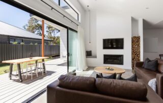 Large sliding glass doors in a living room, pulled open to lead to an outdoor patio