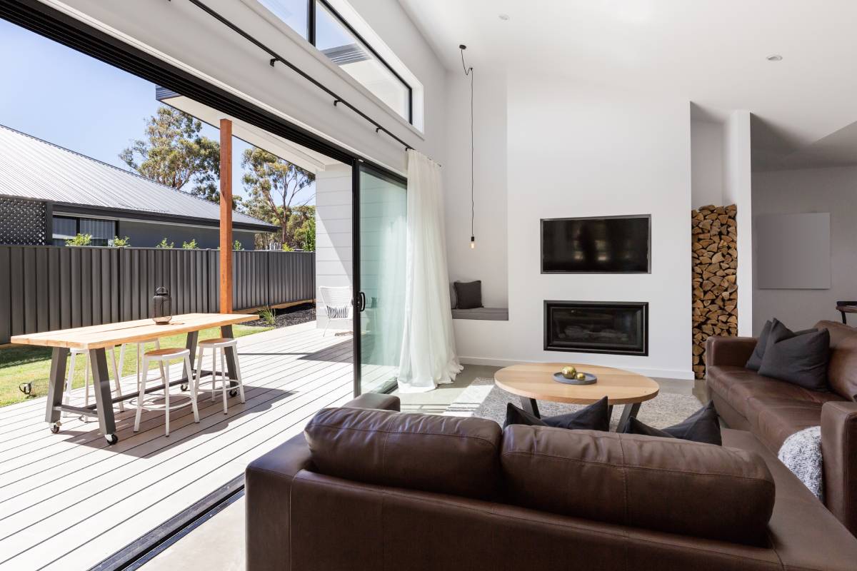 Large sliding glass doors in a living room, pulled open to lead to an outdoor patio