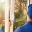 Technician in blue uniform installing a new window in a home near Lexington, KY