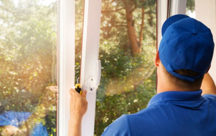 Technician in blue uniform installing a new window in a home near Lexington, KY