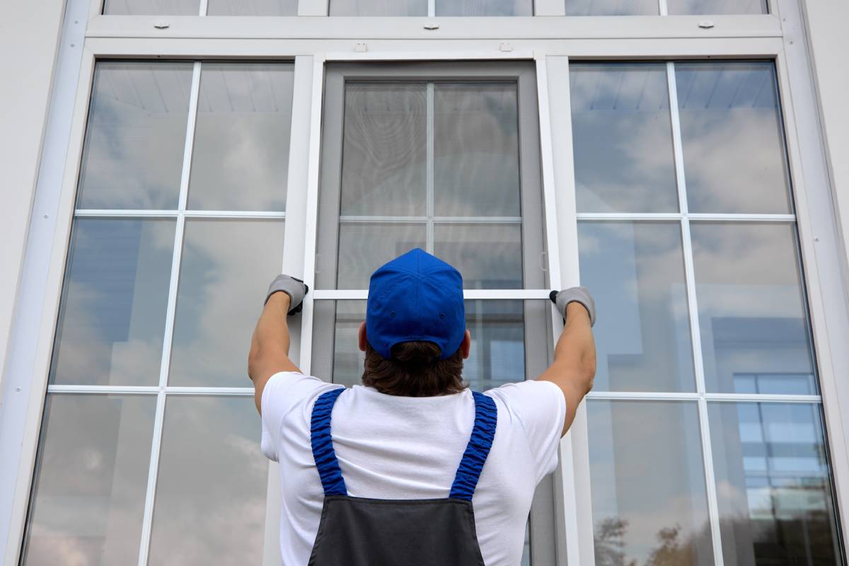 Contractor installing a single window onto a large window pane