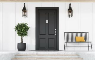 Black entry door against a white exterior with a small tree and bench at Gilkey Windows & Exterior Solutions near Lexington, KY