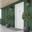 New, white front door on a dark green exterior with modern house lights and potted plants at Gilkey Windows & Exterior Solutions near Lexington, KY