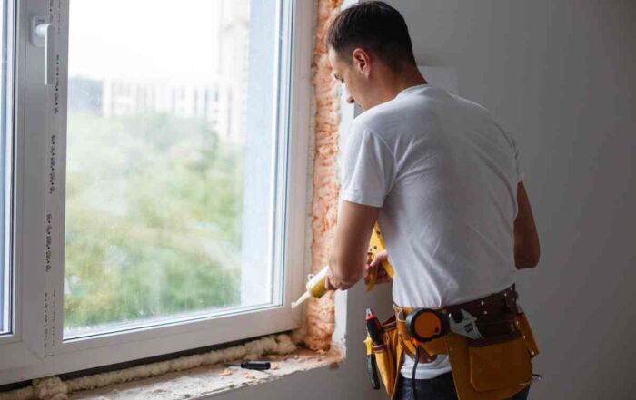 Window expert using caulk as part of the process of installing new windows in a residential home at Gilkey Windows & Exterior Solutions near Lexington, KY