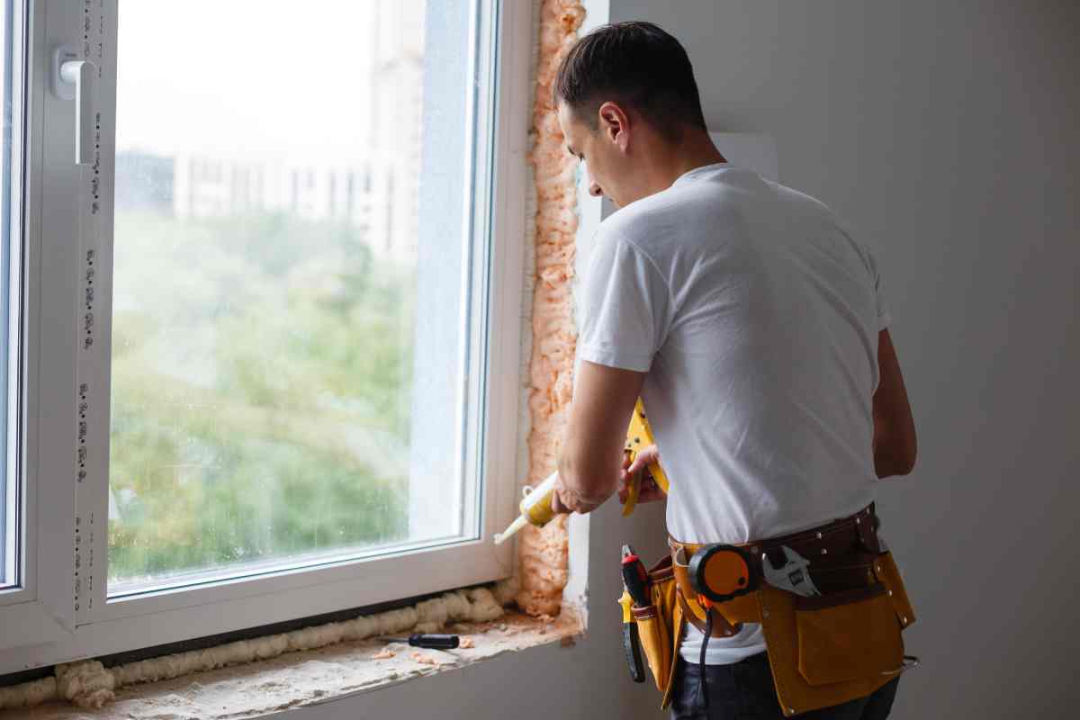 Window expert using caulk as part of the process of installing new windows in a residential home at Gilkey Windows & Exterior Solutions near Lexington, KY