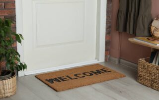 A properly and snugly installed bottom seal on a front door with a welcome mat at Gilkey Windows & Exterior Solutions near Lexington, KY