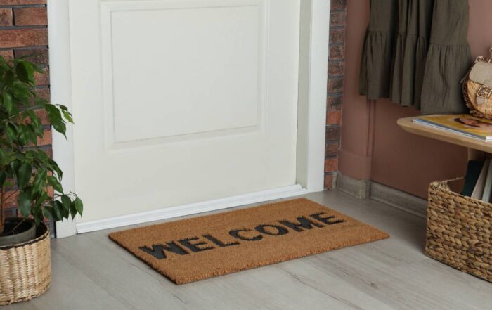 A properly and snugly installed bottom seal on a front door with a welcome mat at Gilkey Windows & Exterior Solutions near Lexington, KY