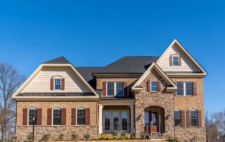 Home with window trim matching the sliding doors and matching exterior shutters to the front door at Gilkey Windows & Exterior Solutions near Lexington, KY