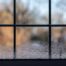 An image focused on window condensation on the glass inside a home during the winter