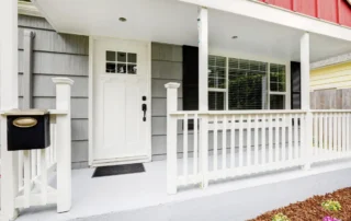 A white front door, a light front door color, on the porch of a home
