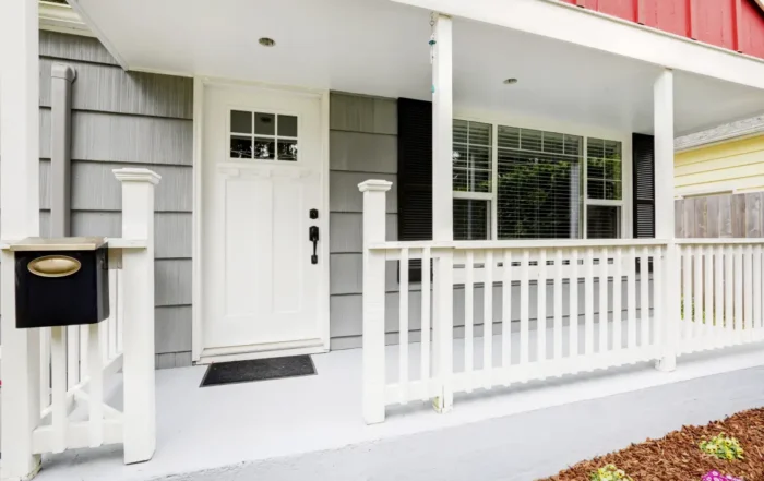 A white front door, a light front door color, on the porch of a home