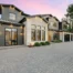 New exterior windows on a beautiful home with outdoor lights on, with a pink sunset
